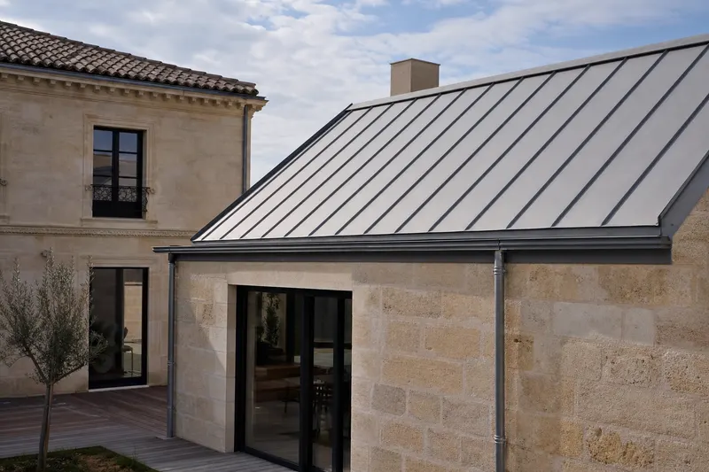 Toiture en zinc à joint debout sur une extension de maison en pierre